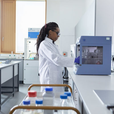 Student checks laptop while working in a lab.