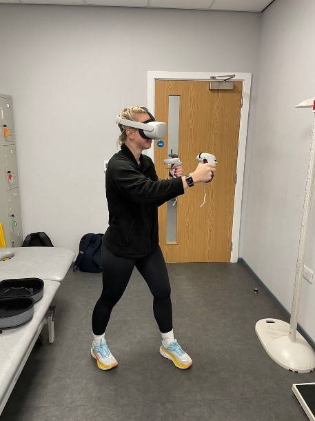 Student wearing a virtual reality headset and holding controllers