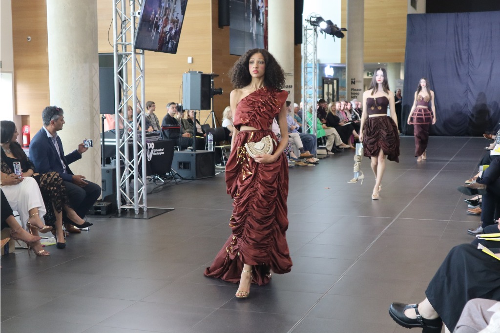 Fashion model walks down catwalk.