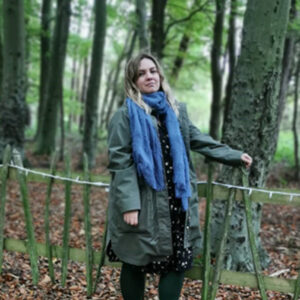 Gemma Robinson-Round, standing outside next to a tree in a forest