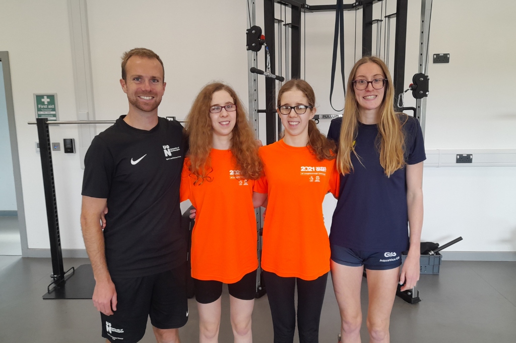 Luke Callis stands next to Paralympic athletes Scarlett Humphrey, Eliza Humphrey and Megan Neave.