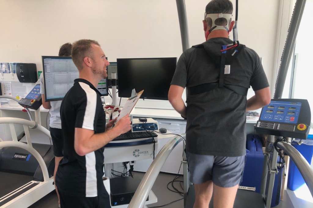 Trainer speaks to runner on the treadmill.