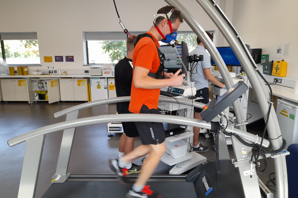 Runner on treadmill wearing VO2 max testing mask.