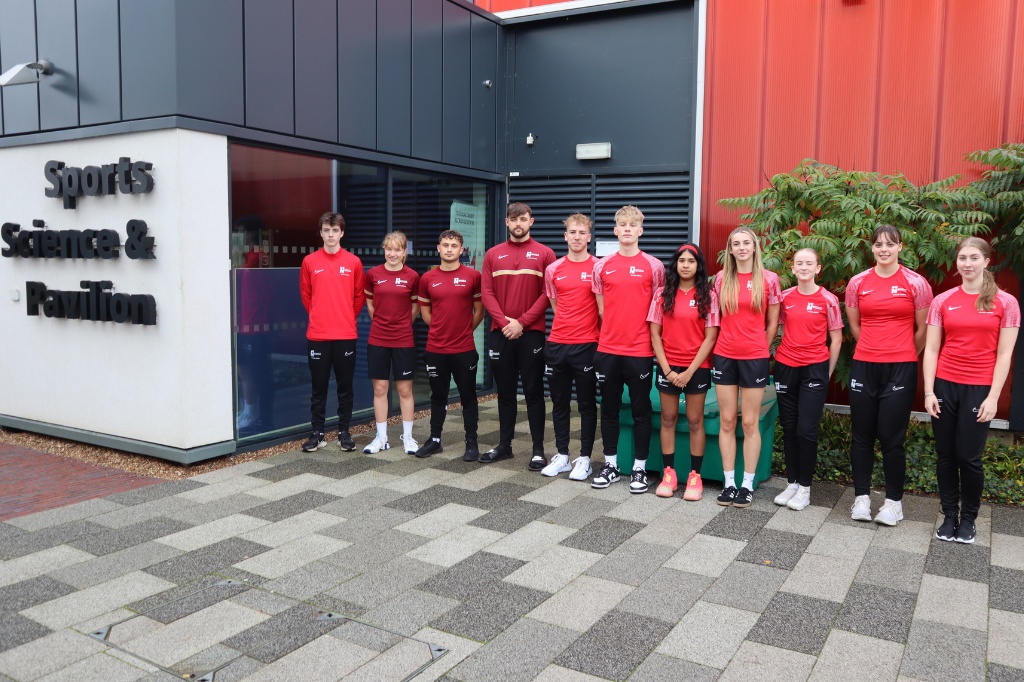 Elite Athlete Scholars stand in front of Sports Pavillion on campus