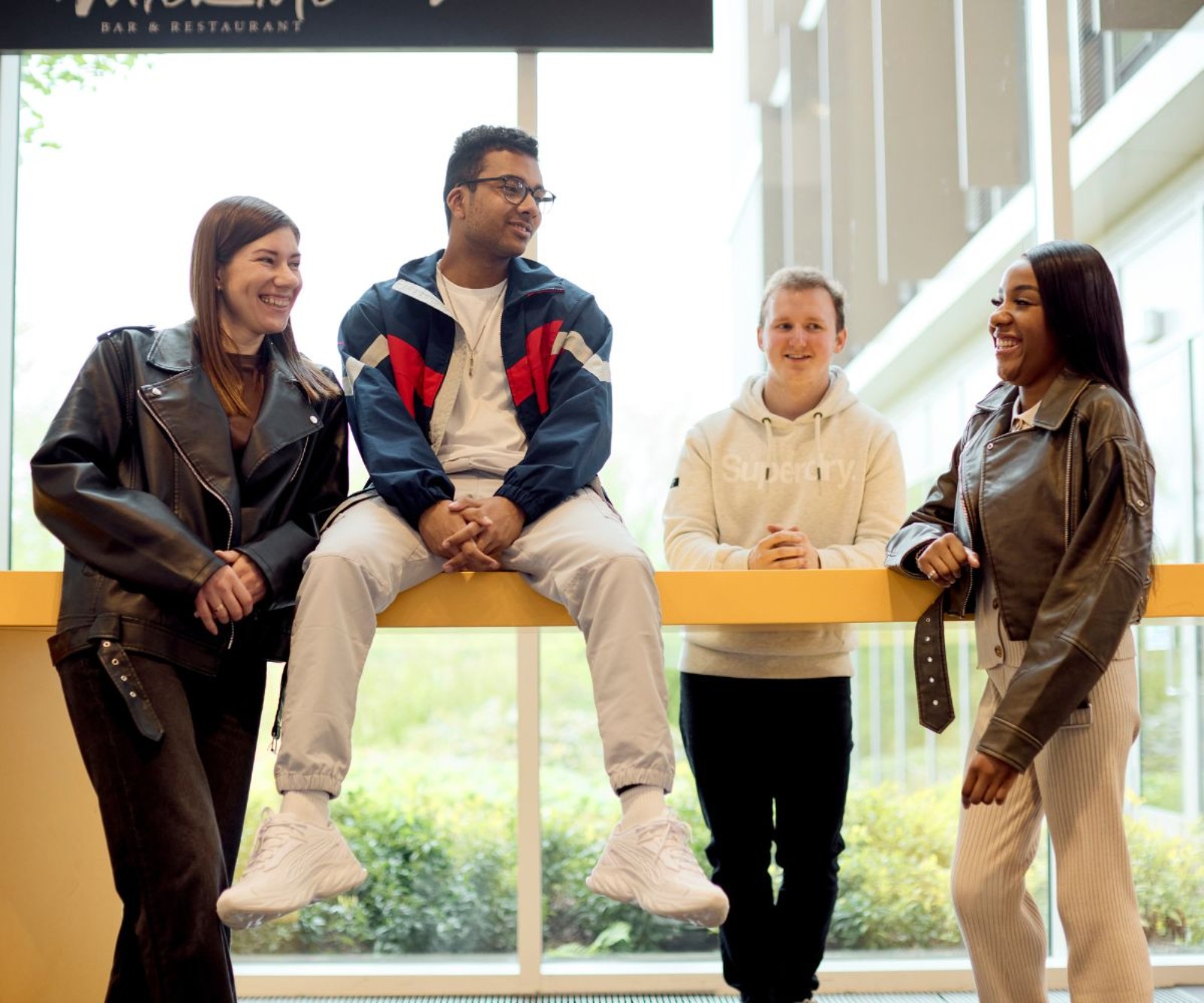 Students around yellow desk in Learning Hub (30 Sep 24)