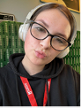 Catherine Cannon, an Education student at UON with headphones and red student lanyard on a train.