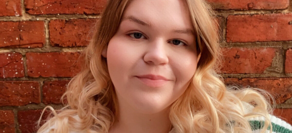 Jessica Wright, Education Studies BA (Hons) smiling at the camera standing in front of a brick wall