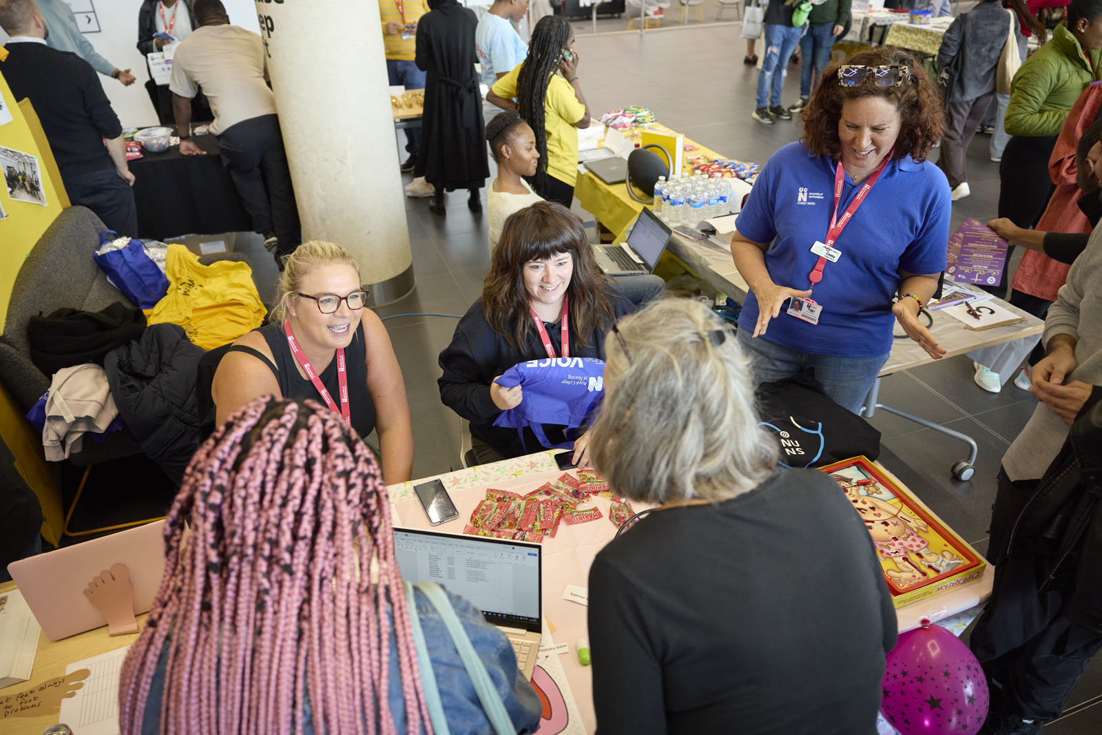 People gathered around a table with laptops and materials during the Student Union Societies fair.